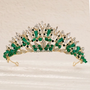 Détail d'une couronne dorée avec pierres précieuses vert émeraude et cristaux de mariée