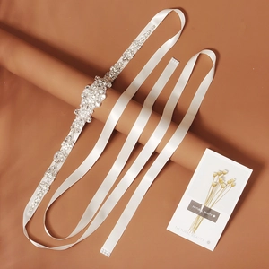 Detail of silver rhinestone floral motif on ivory satin wedding belt for bridal dresses