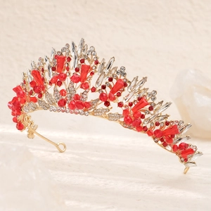 Détail d'une couronne de mariée dorée de luxe avec pierres rouges et cristaux blancs