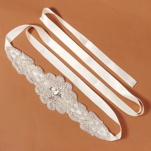 Detail of luxury bridal sash with intricate rhinestone beadwork on ivory satin ribbon