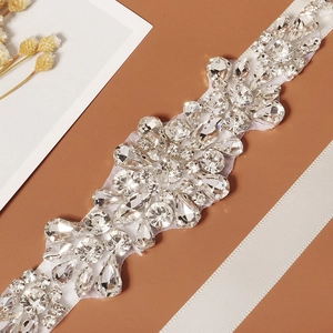 Detail of elegant bridal belt with various rhinestone shapes on white ribbon