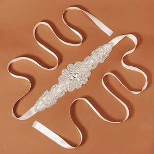 Exquisite bridal sash detail featuring crystal embroidery and white satin ribbon for weddings