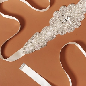 Close-up of luxury bridal belt showing intricate silver rhinestones and beadwork on organza