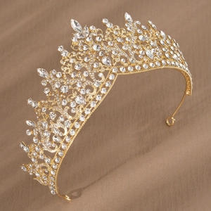 Detail view of gold bridal crown with red crystals and intricate filigree design