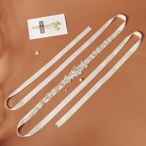 Detail of bridal sash featuring vine floral rhinestones and marquise crystals on white satin