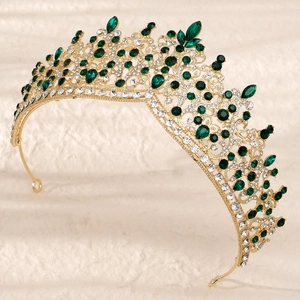 Detailed macro shot of vintage gold crown with emerald crystals and sparkling rhinestones