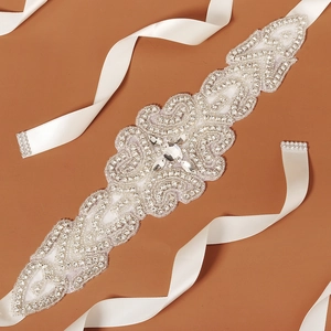 Macro detail of bridal belt featuring silver crystal rhinestones on white satin ribbon