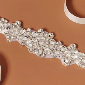 Close-up of teardrop and round rhinestones on mesh base for bridal sash belts