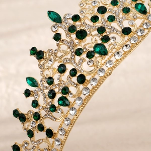 Macro shot of gold tiara with emerald green gems and sparkling white crystals