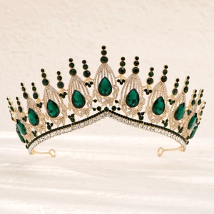 Macro detail of royal gold bridal crown with large green gemstones and sparkling crystals