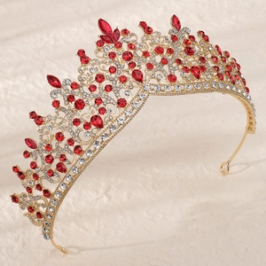 Détails d'une couronne de mariée dorée avec des cristaux rouges en goutte et des strass
