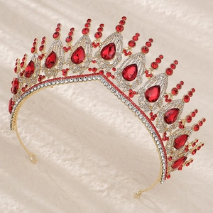 Close-up of golden bridal crown with large red teardrop crystals and small white rhinestones