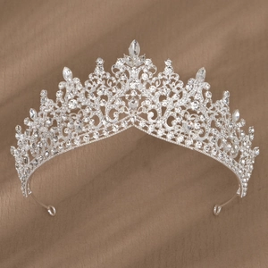 Détail d'une couronne de mariée argentée avec motifs baroques et cristaux rouges