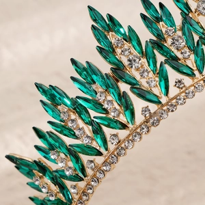 Macro detail of gold leaf crown with emerald marquise crystals and sparkling rhinestones