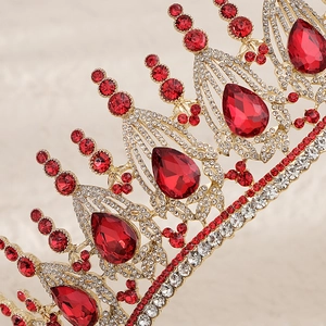 Macro detail of luxury bridal crown with red teardrop crystals and gold metal base