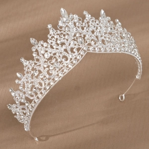 Elegant bridal silver tiara with sparkling rhinestones on a luxurious gold satin background