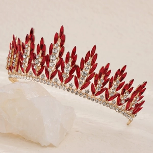 Detailed close-up of golden bridal crown with red crystals and wheat ear leaf design