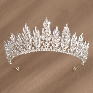 Macro detail of silver bridal tiara with sparkling crystal leaves on leather texture
