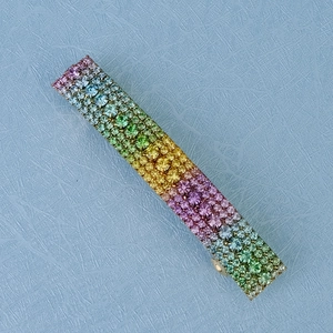 Close-up of rainbow crystal rectangular hair clip with colorful rhinestones on gold base