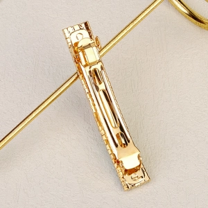 Elegant gold metal hair clip with textured grid pattern and spring closure design