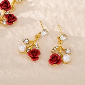 Detailansicht der Brautohrringe mit roten Rosen, weißen Perlen und glänzenden Kristallen