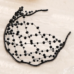 Detail of hand-woven black crystal bead mesh headband with sparkling rhinestone accents