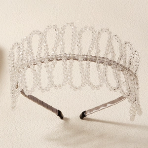 Close-up of elegant crown headband with wave-patterned crystal beads and satin finish