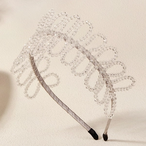 Detailed close-up of a crystal beaded headband with elegant silver-grey satin fabric finish