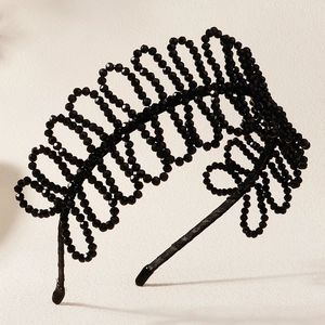 Detailed macro view of handcrafted black beaded crystal headband with wave woven texture