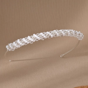 Dettaglio di cerchietto da sposa con perle bianche e cristalli intrecciati a mano