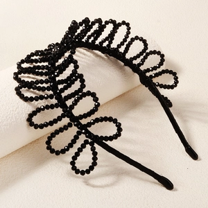 Detail of hand-woven black crystal beads and floral pattern on a premium headband