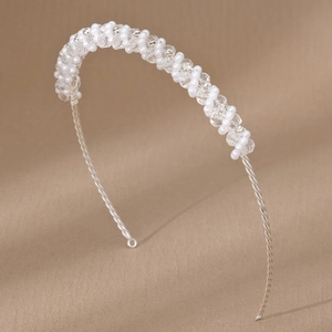Dettaglio di cerchietto da sposa fatto a mano con perle e cristalli su filo d'argento