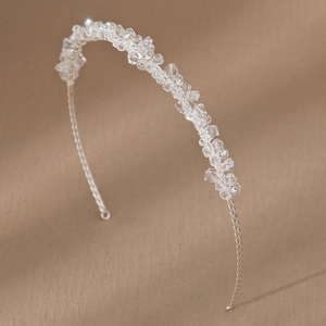 Dettaglio di un cerchietto da sposa fatto a mano con perle di cristallo e filo d'argento