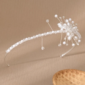 Close-up of handmade bridal headband with white pearls and clear crystal flower clusters