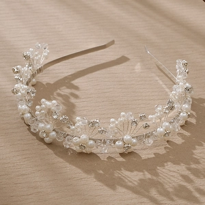 Detail of silver pearl headband with handcrafted crystals on light wood surface