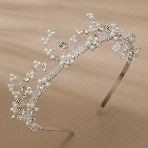 Detail of silver wire headband with white pearls and clear crystals on wood background