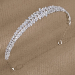 Close-up of sparkling leaf-patterned crystal zircon headband on a warm fabric background