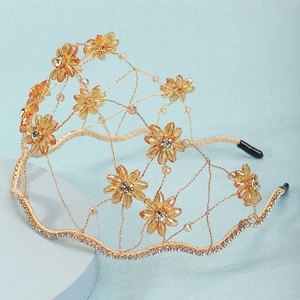 Macro detail of handmade crystal flower headband with gold wire and amber rhinestones