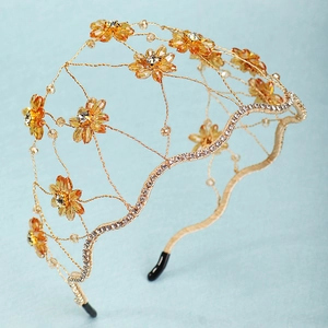 Macro detail of amber crystal flower and gold wire mesh on the bridal headband