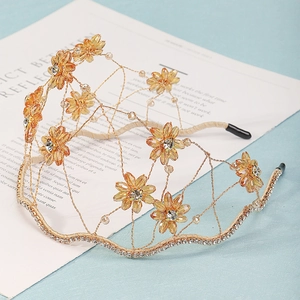 Detailed close-up of handmade champagne gold flower headband with rhinestones and crystals