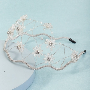 Detail of silver bridal headband featuring crystal flowers and hand-woven mesh structure