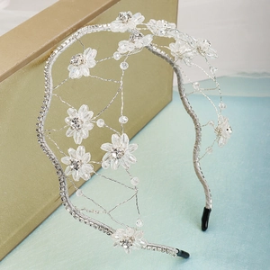 Detailed view of handmade crystal bridal headband with rhinestone flowers and mesh