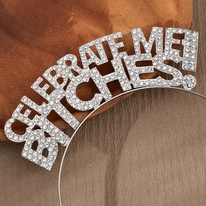 Gros plan d'un serre-tête argenté avec lettrage en strass CELEBRATE ME BITCHES