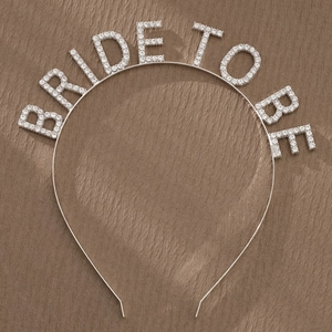 Detailed view of silver Bride To Be headband with sparkling rhinestones on velvet background