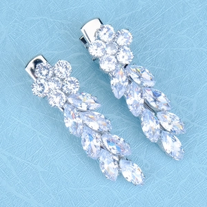 Détail macro de barrettes en zircon avec pierres marquises suspendues sur fond bleu