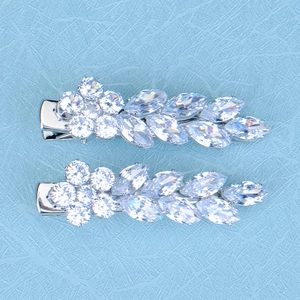Détail de deux pinces à cheveux argentées serties de zircons étincelants en forme de feuille