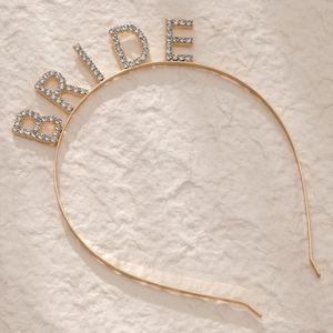 Close-up of golden BRIDE headband with sparkling rhinestones for bridal parties