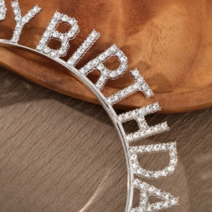 Macro view of crystal rhinestones spelling BIRTHDAY on silver metal birthday headband