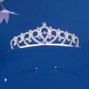 Detailed view of silver crown headband with sparkling white rhinestones on blue surface