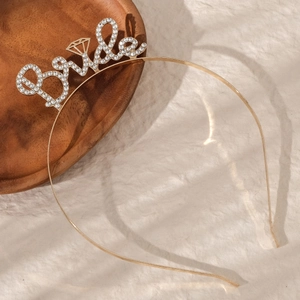 Détail du serre-tête doré avec lettrage Bride en strass et breloque bague en diamant